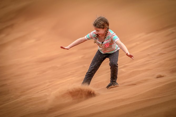 Sandboarding on the red sand dunes Dubai desert adventure