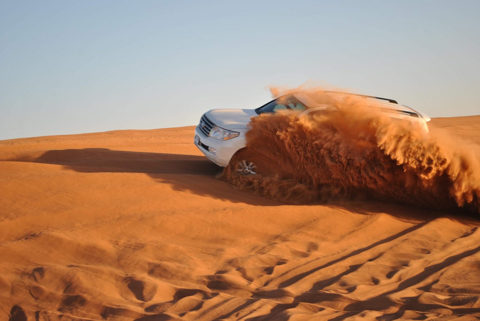 Dune bashing 4x4 Land Cruiser on red sand dunes Dubai desert safari